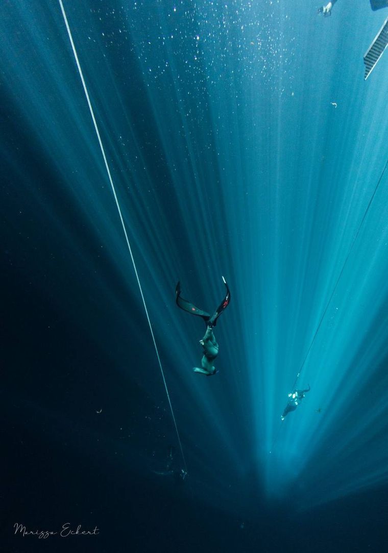 Freediver drifting upside down in the deep blue